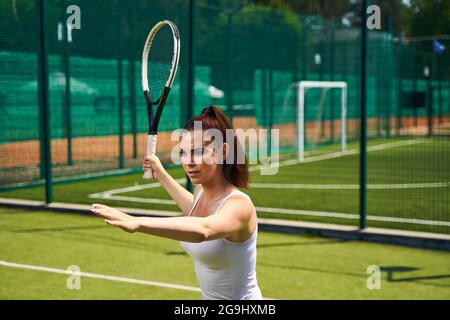 Donna seria messa a fuoco che gioca un gioco di sport Foto Stock