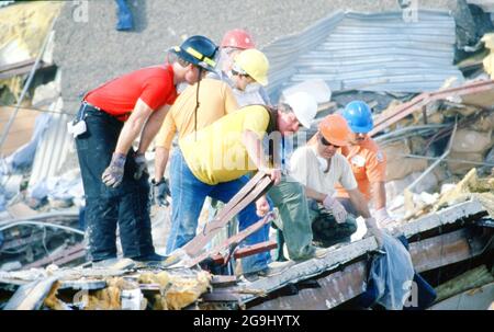 Brownsville Texas USA, luglio 8,1988: Volontari soccorritori pettinare le macerie del negozio Amigo nel centro di Brownsville. Le forti piogge hanno causato il crollo dell'edificio, uccidendo 14 persone. Gli ingegneri hanno individuato una costruzione difettosa su un'aggiunta di terzo piano come la causa del crollo. ©Bob Daemmrich Foto Stock