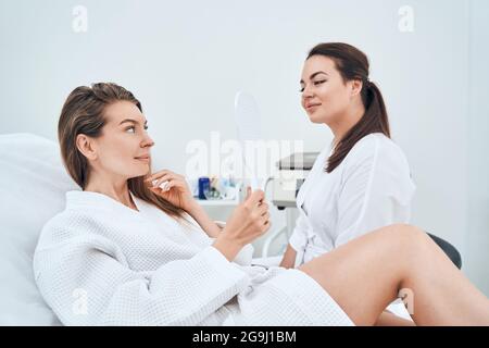 Giovane paziente femminile attento che ha consultazione di bellezza Foto Stock