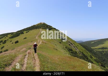 Un alpinista su un sentiero escursionistico sotto la cima del Nadkrstac bella cima delle montagne Vranica in Bosnia Erzegovina Foto Stock