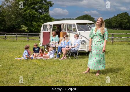 Famiglia a Woodfire Camping vicino Petworth in West Sussex con un campervan VW retro 1966, Inghilterra, Regno Unito Foto Stock