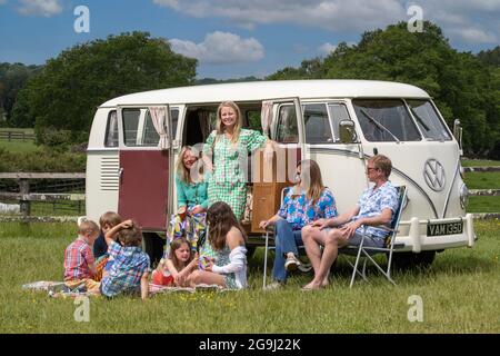 Famiglia a Woodfire Camping vicino Petworth in West Sussex con un campervan VW retro 1966, Inghilterra, Regno Unito Foto Stock