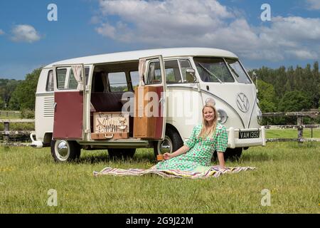 Famiglia a Woodfire Camping vicino Petworth in West Sussex con un campervan VW retro 1966, Inghilterra, Regno Unito Foto Stock