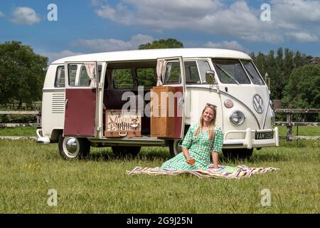 Famiglia a Woodfire Camping vicino Petworth in West Sussex con un campervan VW retro 1966, Inghilterra, Regno Unito Foto Stock