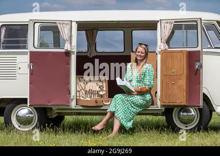 Famiglia a Woodfire Camping vicino Petworth in West Sussex con un campervan VW retro 1966, Inghilterra, Regno Unito Foto Stock