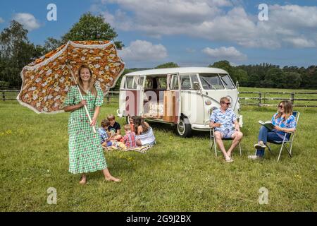 Famiglia a Woodfire Camping vicino Petworth in West Sussex con un campervan VW retro 1966, Inghilterra, Regno Unito Foto Stock