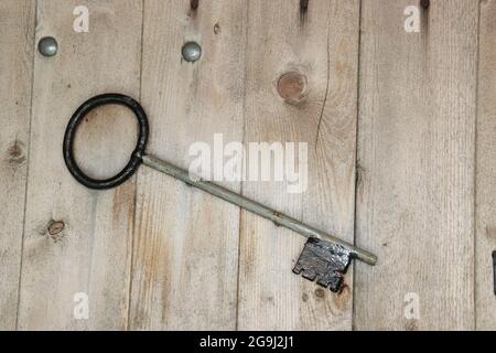 Vecchia chiave di ferro su tavole di legno ruvide Foto Stock