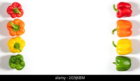 Peperoni dolci colorati su sfondo bianco. Cornice con peperoni verdi, gialli, arancioni e rossi. Verdure fresche e sane. Spazio di copia, vista dall'alto, f Foto Stock