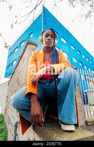 Italia, Milano, donna elegante con cuffie in città Foto Stock