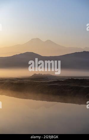 Alba con la nebbia sul fiume e la pianura a Kayseri, di fronte al monte Erciyes Foto Stock