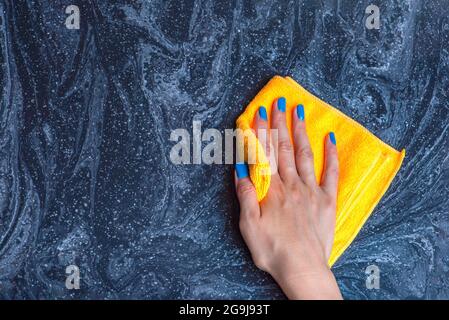 Pulizia del piano di lavoro. Cura per i countertops nella cucina o nel bagno. Pulizia di superfici in pietra, marmo o pietra artificiale. Foto Stock