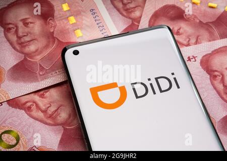 Didi Chuxing Technology logo della società visto su smartphone collocato su 100 yuan banconote. Concetto. Stafford, Regno Unito, 26 luglio 2021. Foto Stock