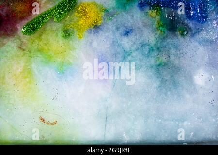 Ghiaccio colorato con glitter, fusione. Glitter e colori! Trasparente e delicato. Bella risorsa grafica. Foto Stock