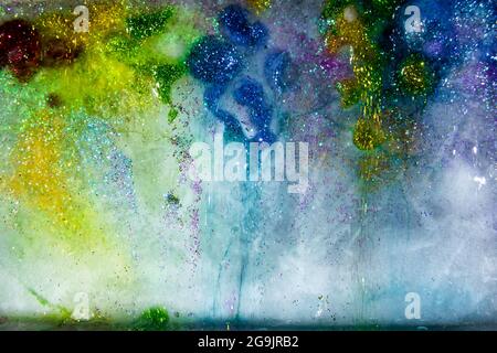 Ghiaccio colorato con glitter, fusione. Glitter e colori! Trasparente e delicato. Bella risorsa grafica. Foto Stock