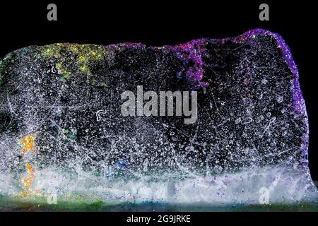 Ghiaccio colorato con glitter, fusione. Glitter e colori! Trasparente e delicato. Bella risorsa grafica. Foto Stock