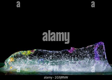 Ghiaccio colorato con glitter, fusione. Glitter e colori! Trasparente e delicato. Bella risorsa grafica. Foto Stock