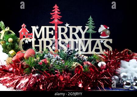 Allegra disposizione di Natale su sfondo nero congratulazioni con stile coni di pino nastro abete fiocco di neve Foto Stock