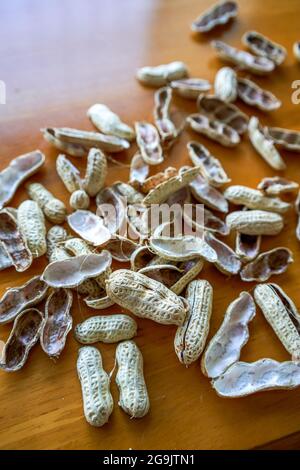 Primo piano di un mucchio di conchiglie di arachidi finite sul tavolo da pranzo Foto Stock