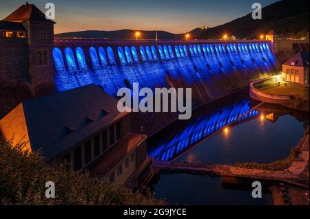 Parete illuminata della diga al crepuscolo serale, Edersee, Ederstausee, Edertalsperre, dietro Schloss Waldeck, Assia, Germania Foto Stock