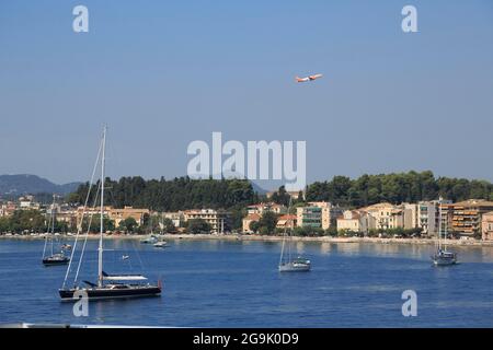 Barche a vela all'ancora di fronte alla città di Corfù o Kerkyra, aereo decollo da Corfù aeroporto, isola di Corfù, Isole IONIE, Mar Mediterraneo Foto Stock