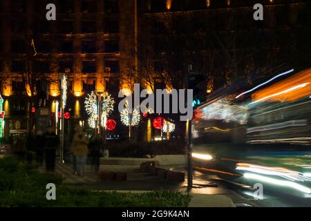 Piazza. Semafori. Persone in attesa. Le persone in attesa che il semaforo cambi in una piazza. Auto di passaggio. Foto Stock