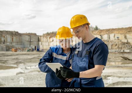 Due colleghi in abbigliamento da lavoro discutono di uno schizzo di nuova costruzione nell'area dell'edificio Foto Stock