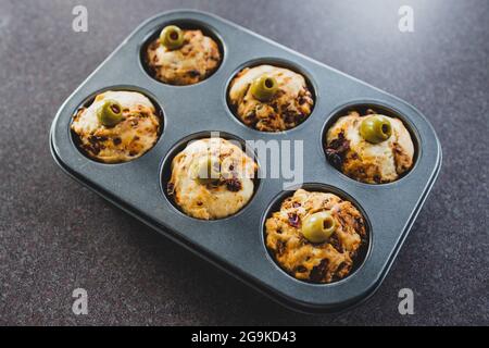 focaccia vegana muffin saporiti con pomodori secchi e olive nel vassoio appena fuori dal forno, salutari ricette a base di piante Foto Stock