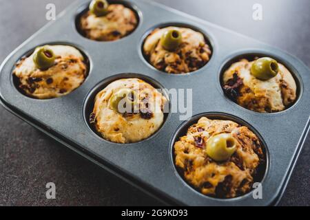 focaccia vegana muffin saporiti con pomodori secchi e olive nel vassoio appena fuori dal forno, salutari ricette a base di piante Foto Stock