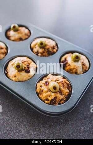 focaccia vegana muffin saporiti con pomodori secchi e olive nel vassoio appena fuori dal forno, salutari ricette a base di piante Foto Stock