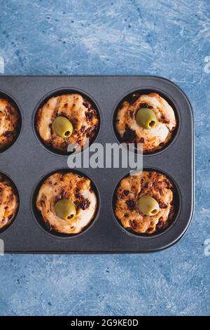 focaccia vegana muffin saporiti con pomodori secchi e olive nel vassoio appena fuori dal forno, salutari ricette a base di piante Foto Stock