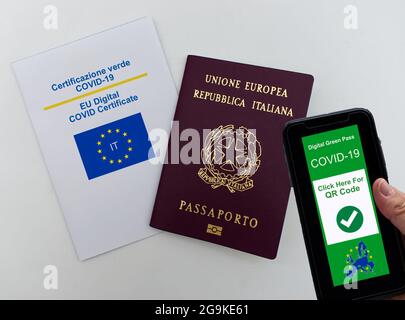 Pass verde digitale Covid-19 dell'UE su smartphone tenuto a mano. Passaporto europeo italiano e certificato Covid-19 digitale UE. Concetto di viaggio sicuro Foto Stock