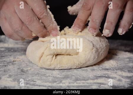 Processo di produzione di pasta fatta in casa per gnocchi, ravioli o pelmeni con carne macinata. Foto Stock