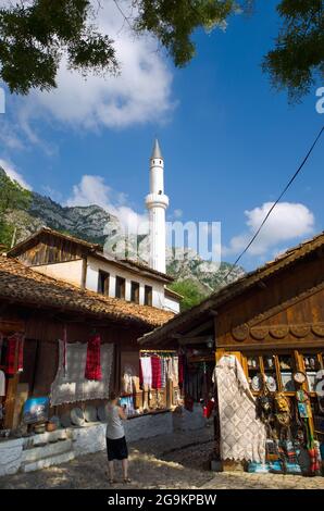 Kruja, Albania - 25 luglio 2012: Un turista scatta una foto della strada del bazar in Kruja; sullo sfondo il minareto contro il cielo blu; il bazar ha un t Foto Stock