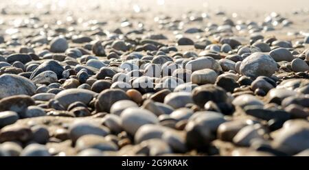 Una vista ravvicinata di pietre levigate e multicolore lavate a riva sulla spiaggia. Foto di alta qualità Foto Stock