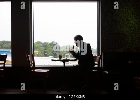 Silhouette of Man Eating al ristorante di London Gateway, vicino alla M1, Regno Unito Foto Stock