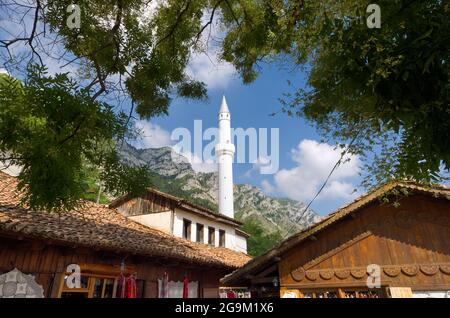 Il bazar ottomano a Kruja e il minareto bianco contro il cielo blu Foto Stock