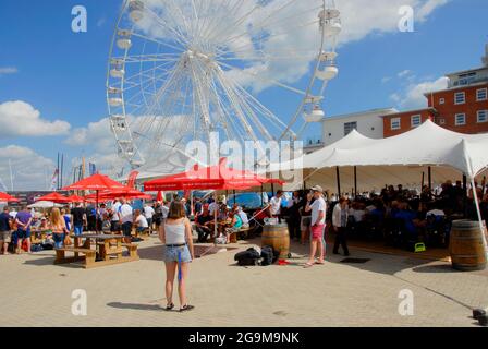 Donna che guarda la ruota panoramica durante la regata di Cowes Week, Isola di Wight, Inghilterra Foto Stock