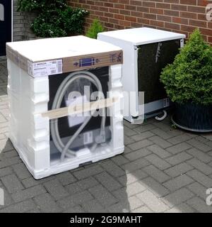 Nuovo apparecchio per lavastoviglie domestico Bosch, confezione in polistirene consegnata alla casa dei clienti accanto alla vecchia macchina difettosa per il riciclaggio nel Regno Unito Foto Stock