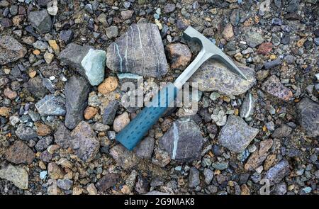 I geologi dell'acciaio raccolgono sullo sfondo di rocce serpentine multicolore nella miniera di amianto Foto Stock