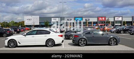 Vista laterale file di parcheggio auto gratuito nel Chelmsford Clock Tower Retail Park fuori M&S food Store Factory Village SCS & DFS negozi fronts Inghilterra Essex UK Foto Stock