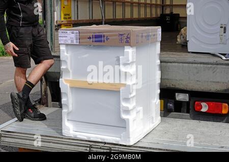 Driver per la consegna a domicilio del grande magazzino John Lewis sul portellone del camion per il nuovo apparecchio per lavastoviglie domestico Bosch White Goods in confezioni in polistirene UK Foto Stock