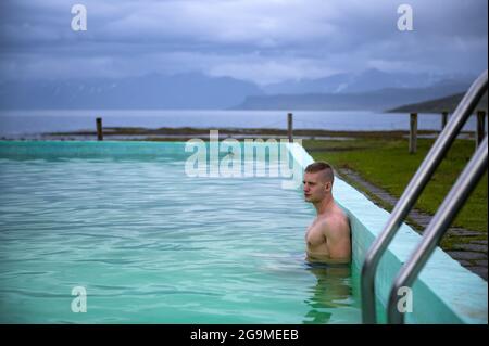 Bagni per ragazzi nella piscina riscaldata di Reykjafjardarlag, situata a Westfjords, Islanda Foto Stock