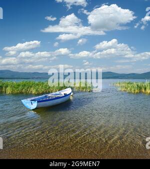 Paesaggio torbido su una barca a remi ormeggiata nel lago di Prespa, Repubblica di Macedonia Foto Stock