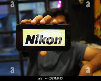 KOLKATA, INDIA - 23 luglio 2021: Un uomo indiano che mostra il logo di Nikon , una multinazionale giapponese con sede a Tokyo, Giappone, specializzi Foto Stock