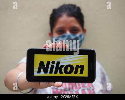 KOLKATA, INDIA - 26 luglio 2021: Una ragazza indiana che mostra il logo di Nikon , una multinazionale giapponese con sede a Tokyo, Giappone, specializziz Foto Stock