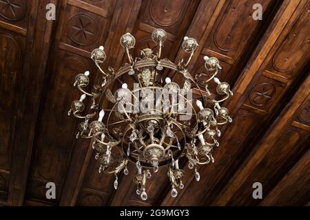 grande lampadario d'epoca nel palazzo sul soffitto vicino. Foto Stock