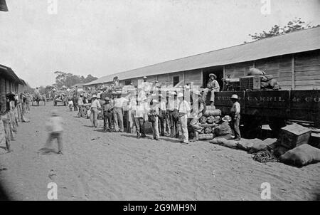 PUNTARENAS, COSTA RICA - circa 1880-1900 - lavoratori con carico (probabilmente banane e caffè tra loro) presso il deposito ferroviario a Puntarenas, Costa Rica Foto Stock