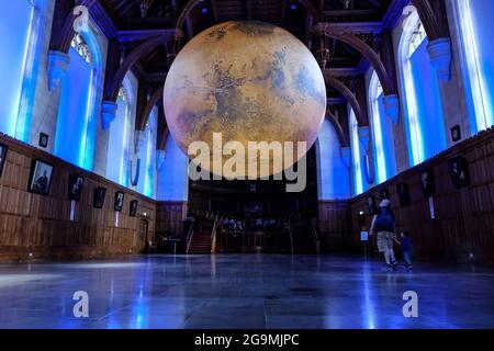 Bristol, Regno Unito. 27 luglio 2021. Luke Jerram mostra il suo modello di Marte di sette metri nella Grande Sala del Wills Memorial Building Bristol University. Utilizzando le immagini della NASA, il modello consente alle persone di vedere le montagne, le valli e i crateri del nostro vicino pianeta Rosso. La mostra sarà aperta al pubblico, al personale e agli studenti dal 27 luglio al 1 agosto. Credit: JMF News/Alamy Live News Foto Stock