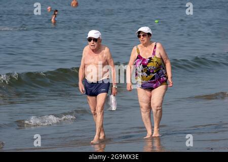 Una coppia più anziana, presumibilmente marito e moglie, cammina lungo la costa di Brighton Beach a Brooklyn, New York City. Foto Stock