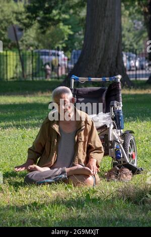 Un uomo di 86 anni fa Falun gong slow-moving esercizi vicino ad un albero. A Queens, New York, un posto molto diverso. Foto Stock